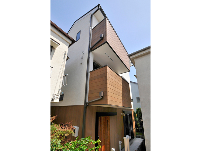 旗竿地を活用した3階建て。外観は木質感を取り入れて温もりをプラス。